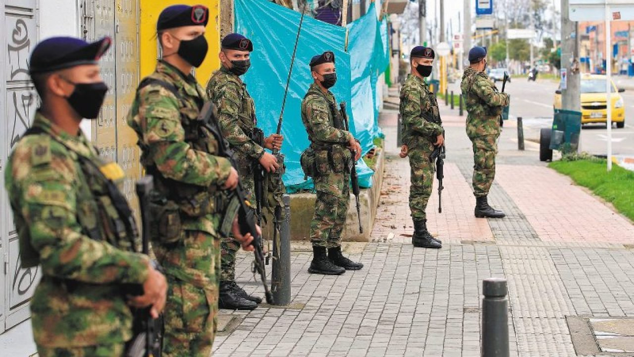 Soldiers patrol the streets in Bogota on May 2, 2021, after the Colombian president ordered the military to be deployed in the main cities of the country where severe riots erupted during protests against a tax reform plan. Tens of thousands of Colombians protesting a tax reform plan took to the streets Saturday for the fourth straight day, even after President Ivan Duque vowed to withdraw the most unpopular parts of the package. Many Colombians had complained that the tax changes would leave them poorer in the middle of the coronavirus pandemic. / AFP / Daniel MUNOZ