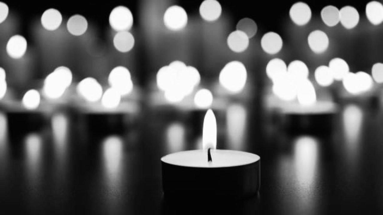 Burning candle on black table. Memory day