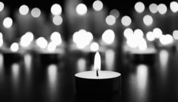 Burning candle on black table. Memory day
